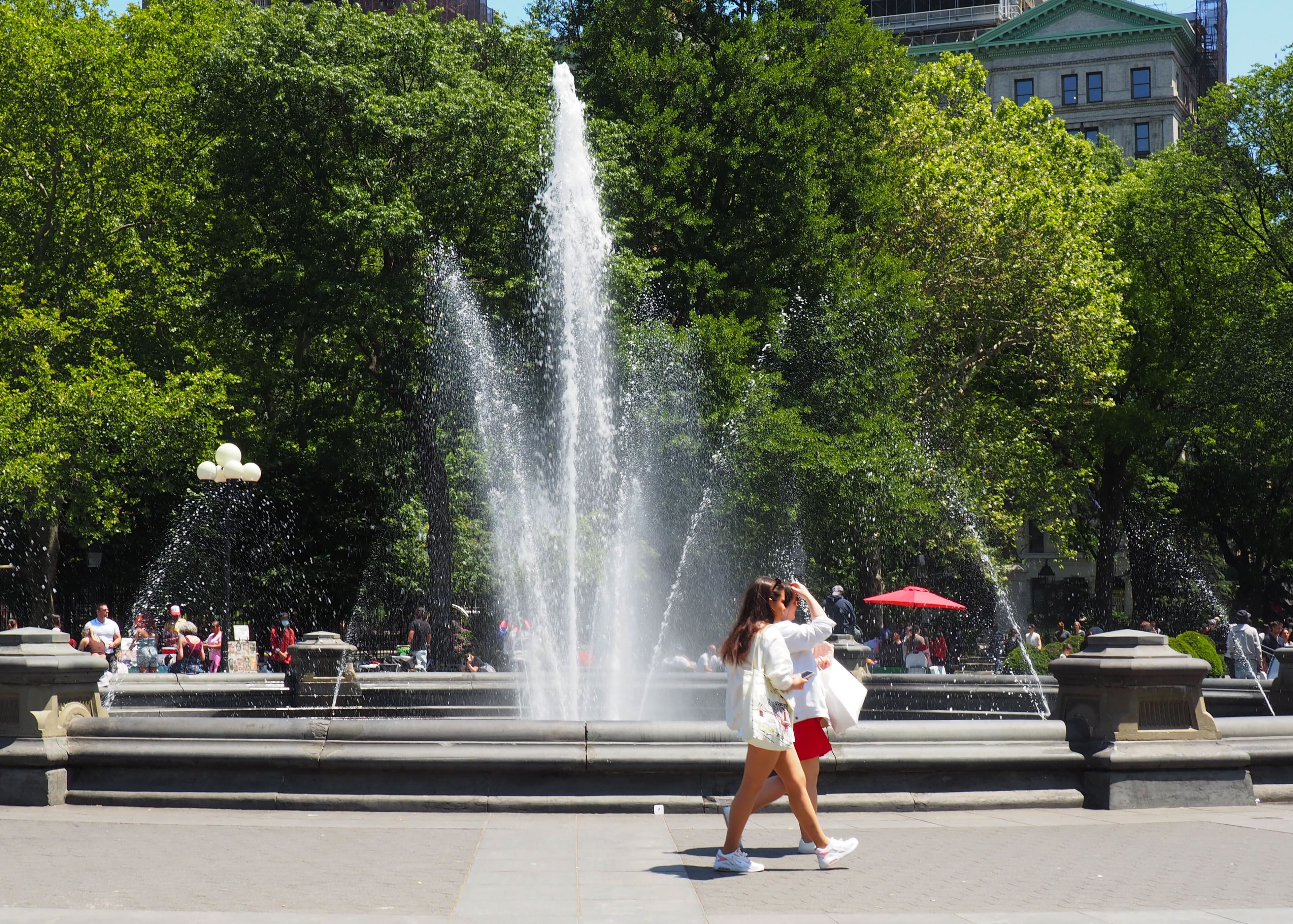 A person walks by the Washington Square Park fountain.