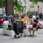 people of varying ages sit in a circle at the DrawNYC pop-up studio in the park