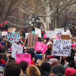 protesters in the park hold up signs in support of reproductive rights