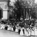20,000 workers – a quarter of them women – march down Fifth Avenue and through the Arch to rally in the Park for improved working conditions in 1912.