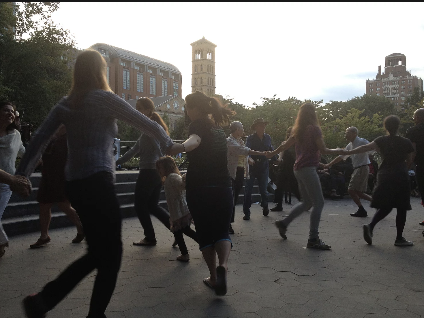 two groups of people holding hands to form two circles in garibaldi plaza