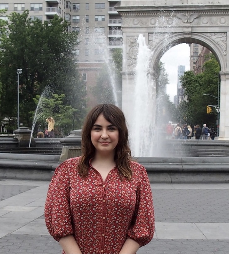 WSP program manager Kaitlyn Yates smiling and standing in front of fountain with arch in the background