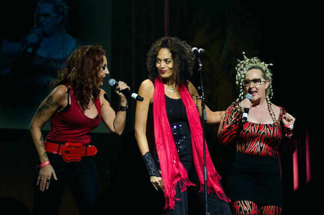 three women singing on a stage